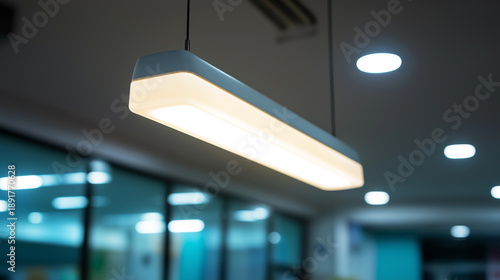 Modern linear light fixture illuminating a dim office space, presenting an energy efficient ceiling concept