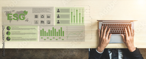 Fotografie Explore the intricacies of ESG reporting through a detailed infographic showcasing charts, graphs, and data analysis on a wooden desk with a laptop