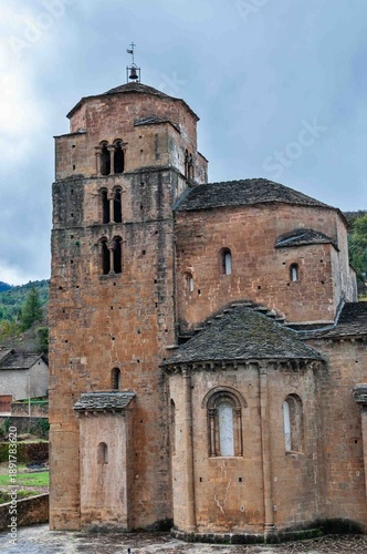 A large brown building with a steeple and a weather vane on top