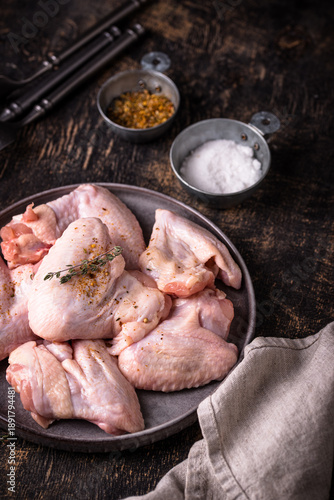 Raw chicken wings on black background.