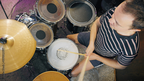 Fotografie High-angle shot of a young man playing the drums with passion