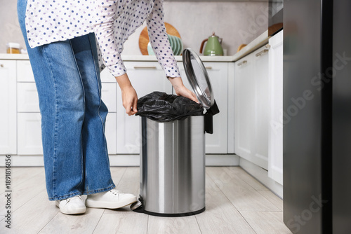 Εκτύπωση καμβά Woman putting garbage bag into trash can in kitchen, closeup