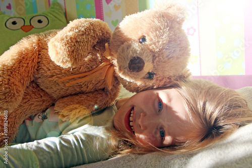 Little girl playing with teddy bear. Summer vacation with beloved dog