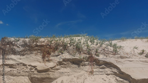 White sand dunes on the beach with blue sky and white clouds
