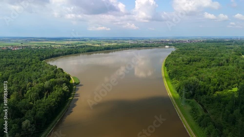 Climate change impact at Faiminger Stausee reservoir in Lauingen, Germany. Aerial view of dirty sediment in the Danube water after high water levels and overflow in the Bavarian region.