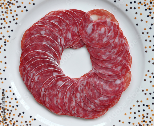 Sausage pieces laid in a circle on a white plate