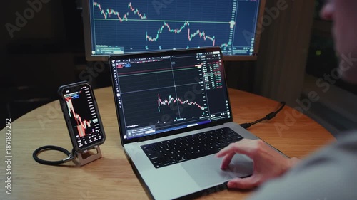 Man stock trader in home office. Male analyzes terminal, trades stocks on crypto market. Quotes from Bitcoin Ethereum, or funds. Candlestick or trading charts, price action on the laptop screen. Night