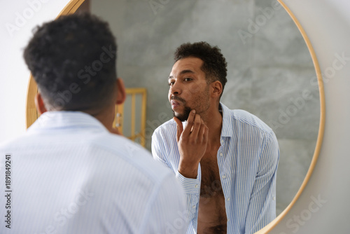 Konstfotografi Handsome man looking at himself in mirror at home