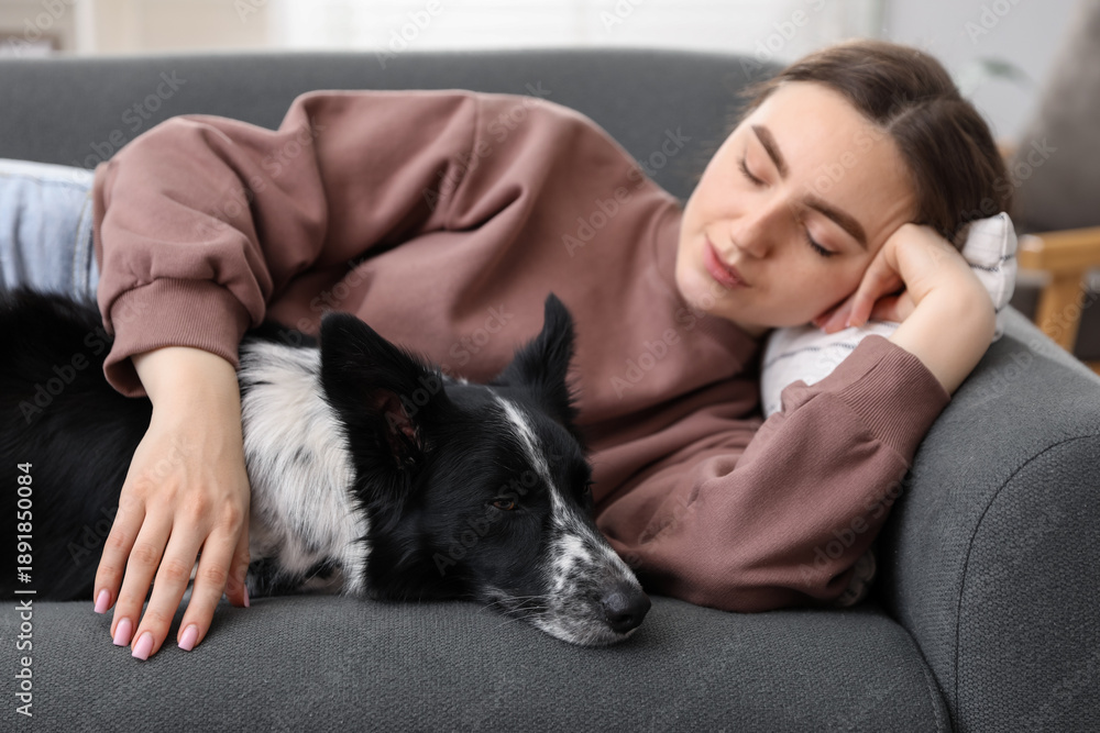 Obraz premium Young woman with her adorable dog sleeping on sofa at home