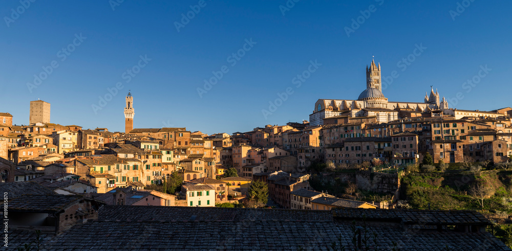 Obraz premium Siena, Italy - March 27, 2019. Scenic view of old town of Siena in a sunset light