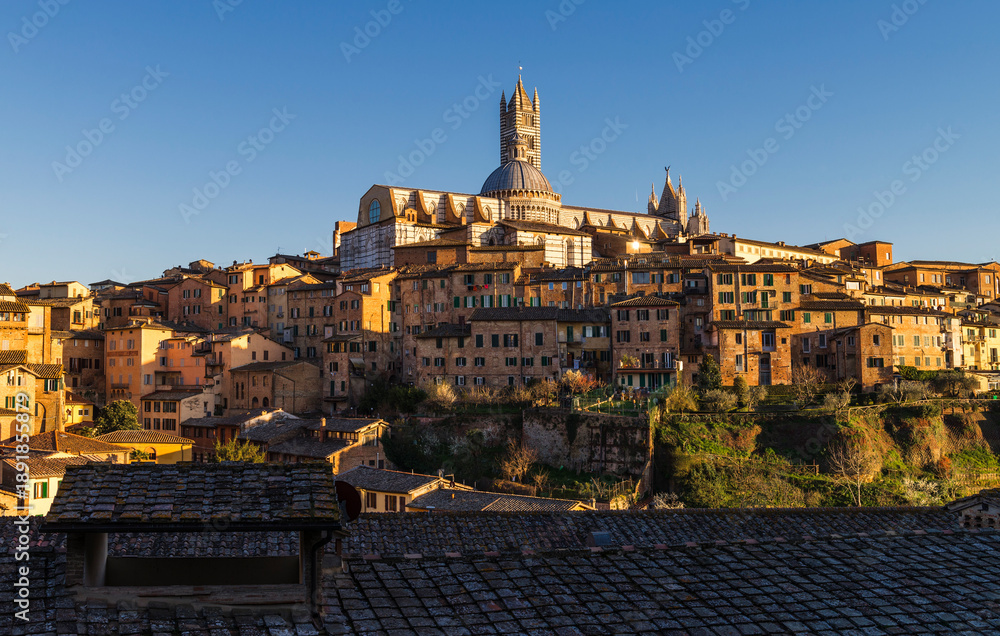 Obraz premium Siena, Italy - March 27, 2019. Scenic view of old town of Siena in a sunset light