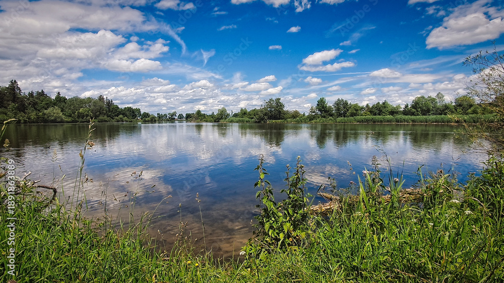 Obraz premium Peaceful picturesque mesmerizing atmospheric landscape at lake with on summer day with blus sky and clouds mirrow reflected in lake water