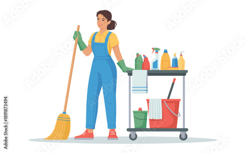 A janitor in blue overalls stands beside a cart filled with cleaning supplies holding a mop and a cloth in a tidy environment from a front viewpoint