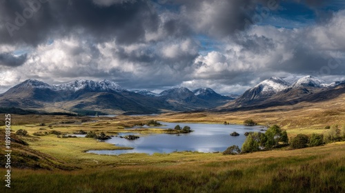 Monochrome winter scenery featuring a majestic mountain range reflected in a tranquil loch on a vast moorland
