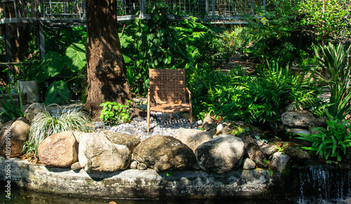 Wicker chair on backyard garden in the summer
