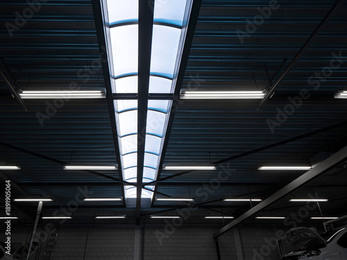 Slika na platnu Industrial warehouse ceiling with long skylight and fluorescent tube lights, dar