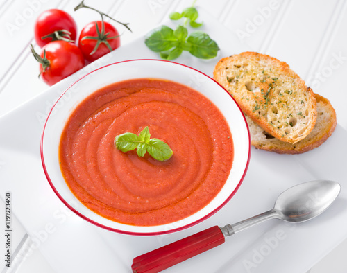 Fresh raw tomato soup made from vine ripe tomatoes in a white bowl served with toasted bread