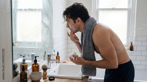 Shirtless Man Applying Moisturizer Face Cream In Bathroom Mirror Morning Routine