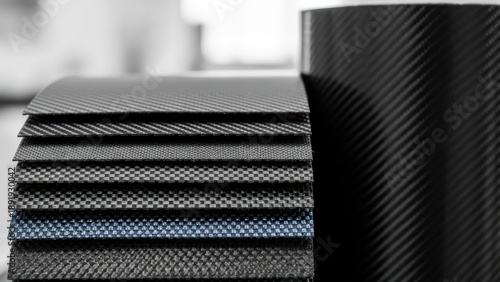 Modern carbon fiber composite material sheets stacked in gradient arrangement with single blue layer, advanced industrial texture pattern for high performance engineering design