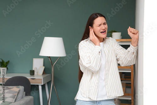 Young woman knocking on wal...