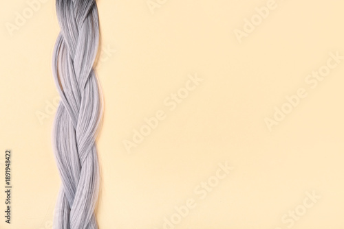 Fotografie Braided grey hair on beige background