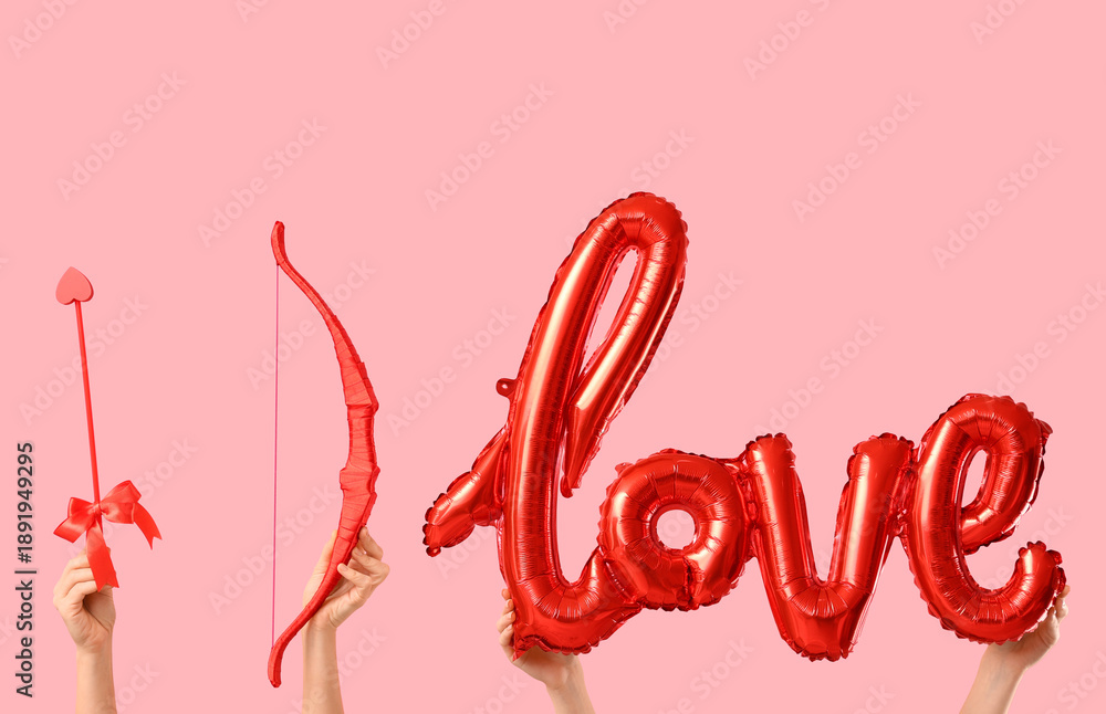 Fototapeta premium Female hands with cupid's bow, arrow and balloon in shape of word LOVE on color background. Valentine's Day celebration