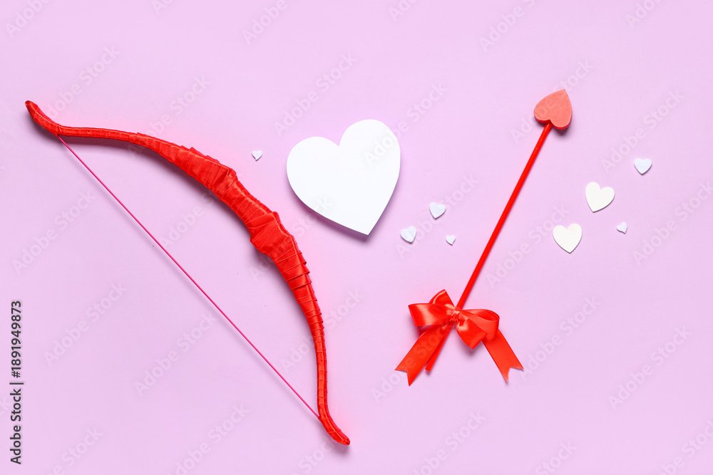 Fototapeta premium Composition with cupid's bow, arrow and paper hearts on lilac background. Valentine's Day celebration