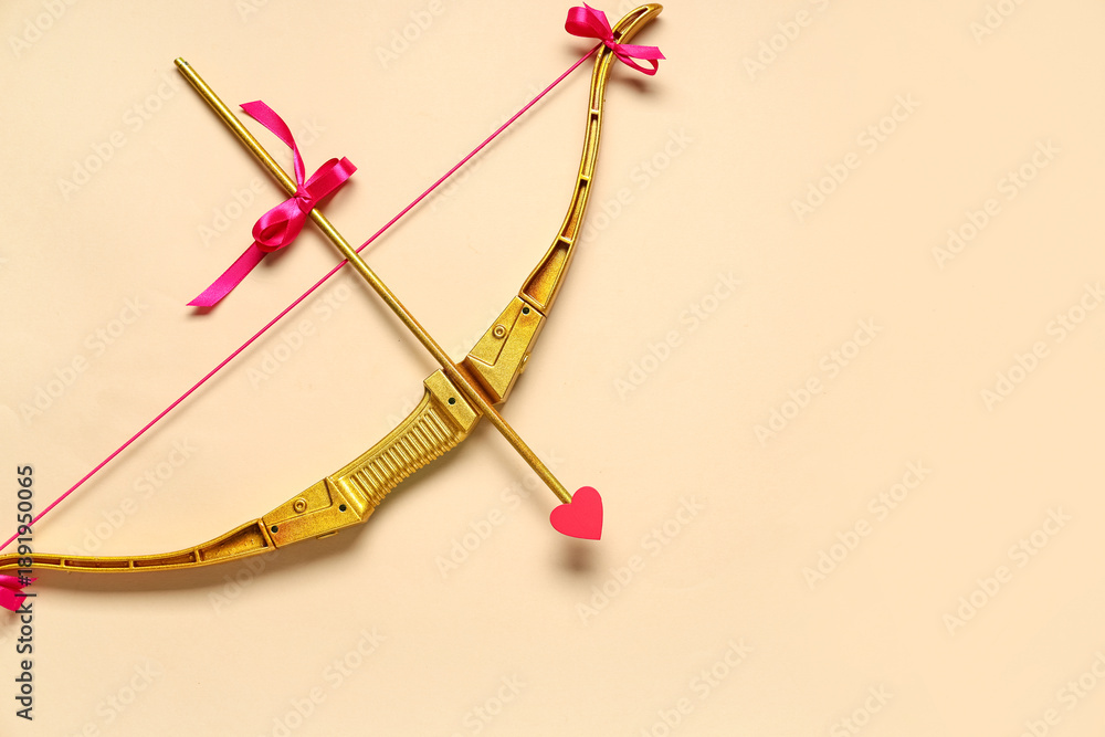 Fototapeta premium Golden cupid's bow with arrow on color background. Valentine's Day celebration