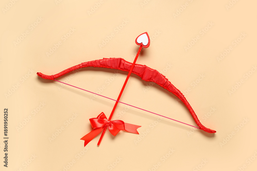 Obraz premium Red cupid's bow on color background. Valentine's Day celebration