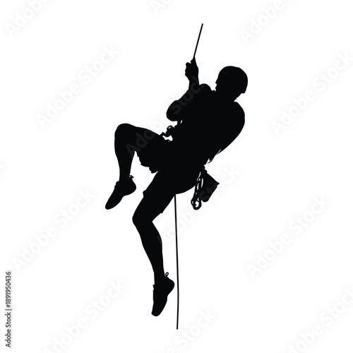 Silhouette of man rappelling down rope