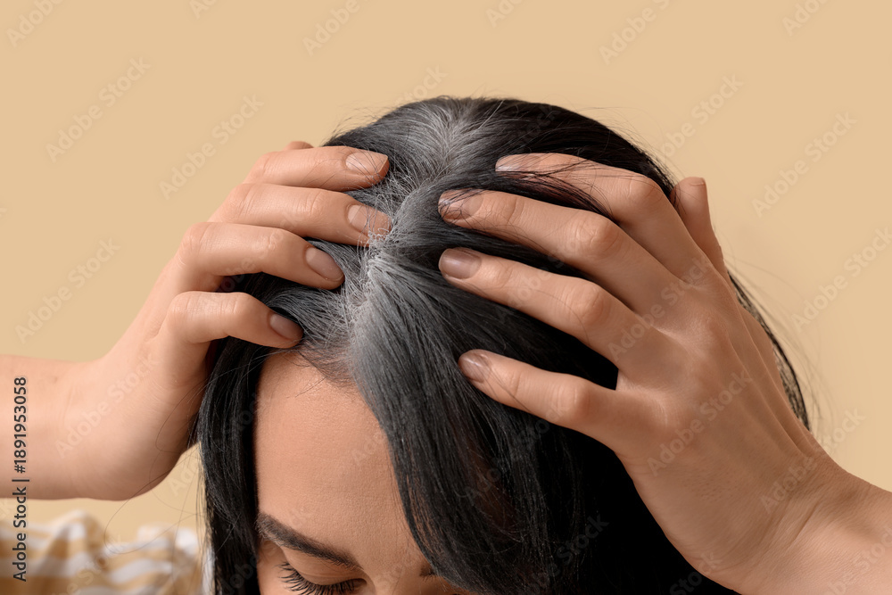 Fototapeta premium Young woman with graying hair on beige background, closeup