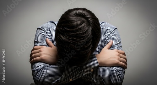 A person feeling sad and alone, with their arms wrapped around themselves, conveying a sense of isolation and despair