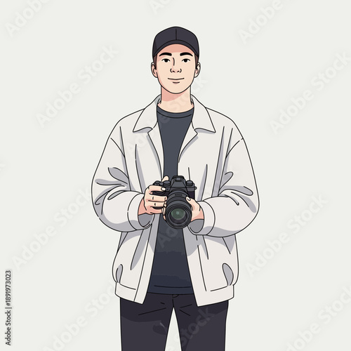 Young man holding a professional camera, wearing a jacket and cap