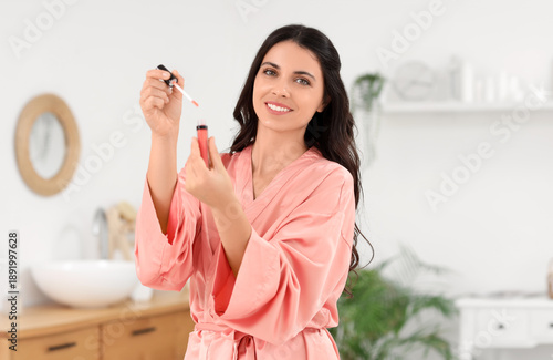 Εκτύπωση καμβά Beautiful young happy woman with lipgloss doing makeup in bathroom