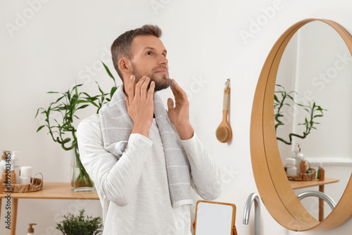 Young man applying cream to...