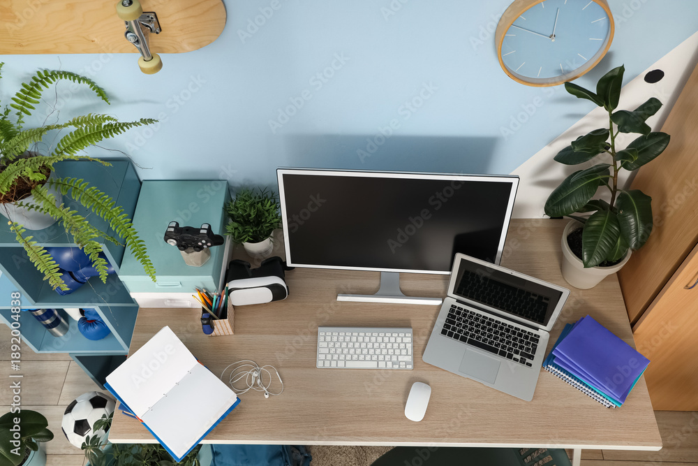 Fototapeta premium Teenager's workplace with laptop, computer and plants in room