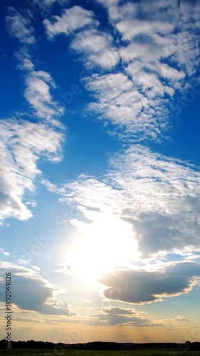 Wallpaper Mural Radiant golden sun piercing through scattered clouds above a vast, dark green landscape Torontodigital.ca