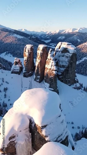 Wallpaper Mural Golden light bathes towering snow-covered rock formations in a vast winter mountain range Torontodigital.ca