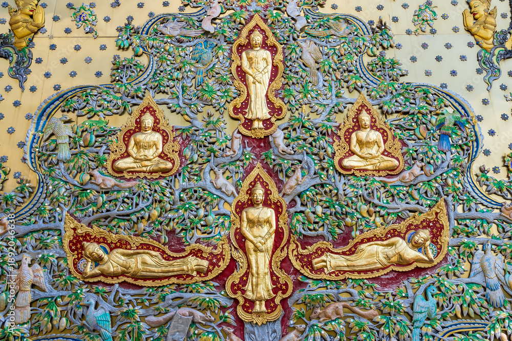 Obraz premium Chiang Mai, Thailand - January,08, 2026:The Ornate Mural: Intricate gold statues of figures adorn a richly detailed mural, showcasing artistic craftsmanship. A vibrant and meaningful cultural piece.