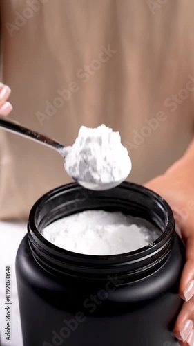 Wallpaper Mural Hand scooping white powder from a large black container Torontodigital.ca