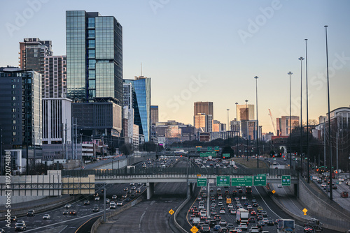 View of the Downtown Atlanta Skyline Cityscape showing several prominent buildings, highways, cars, and hotels after sunrise.