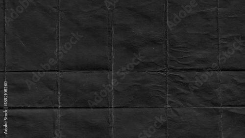 Folded black paper texture revealing creases and detailed folds for a dark and textured background