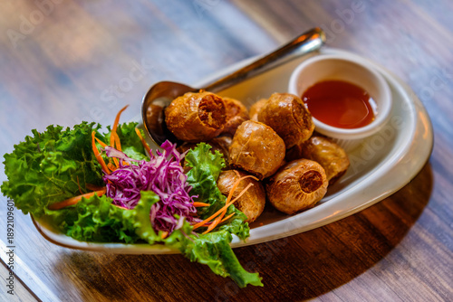Tableau sur toile Deep fried crab meat roll serving with chillies sauce on wooden table