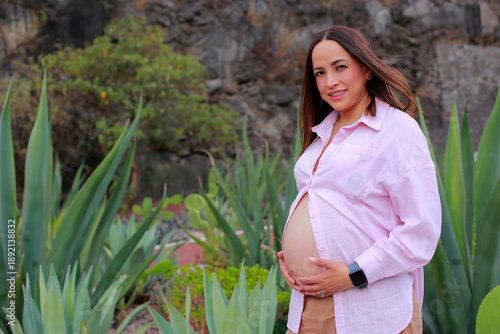 Smiling pregnant woman enjoys free time in the park