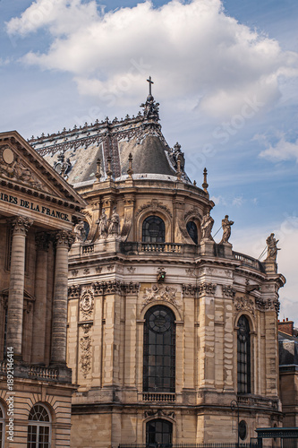 A beautiful wing from apalace in Paris, France, on a picturesque, cloudy blue sky.