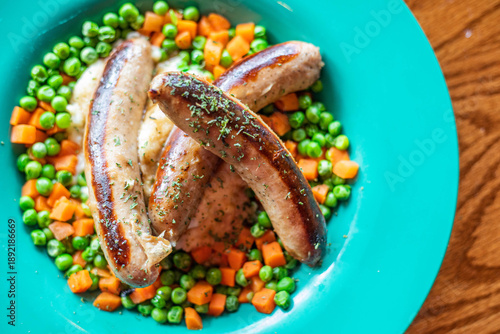 Fotografie Bangers and mash on a bright blue plate in a well lit Irish pub restaurant