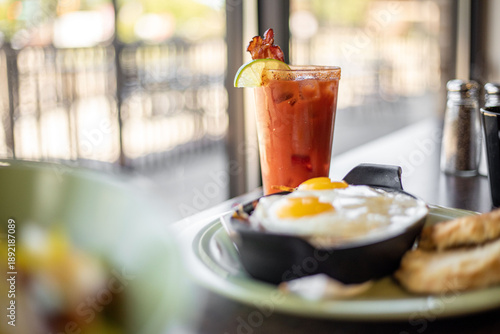 Schilderij op canvas A bloody mary beverage cocktail with two eggs near a bright window at a modern b
