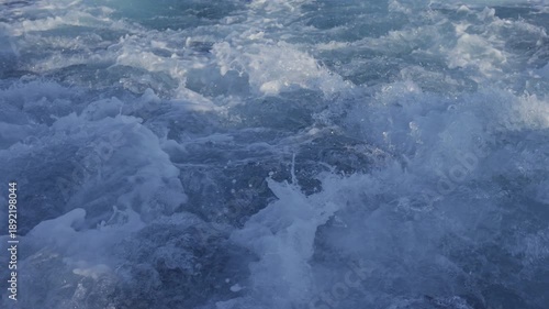 Detailed view of foamy blue ocean water in motion.