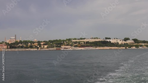 Panoramic view of Istanbul's historic peninsula across the Bosphorus Strait, featuring Hagia Sophia and Topkapi Palace under a cloudy sky.