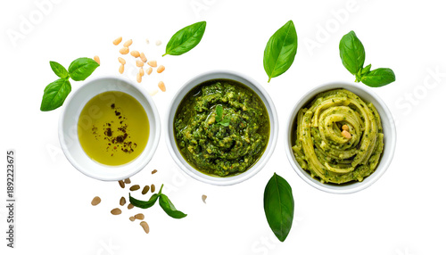 Three white bowls display various pesto sauces with basil leaves, pine nuts, and olive oil